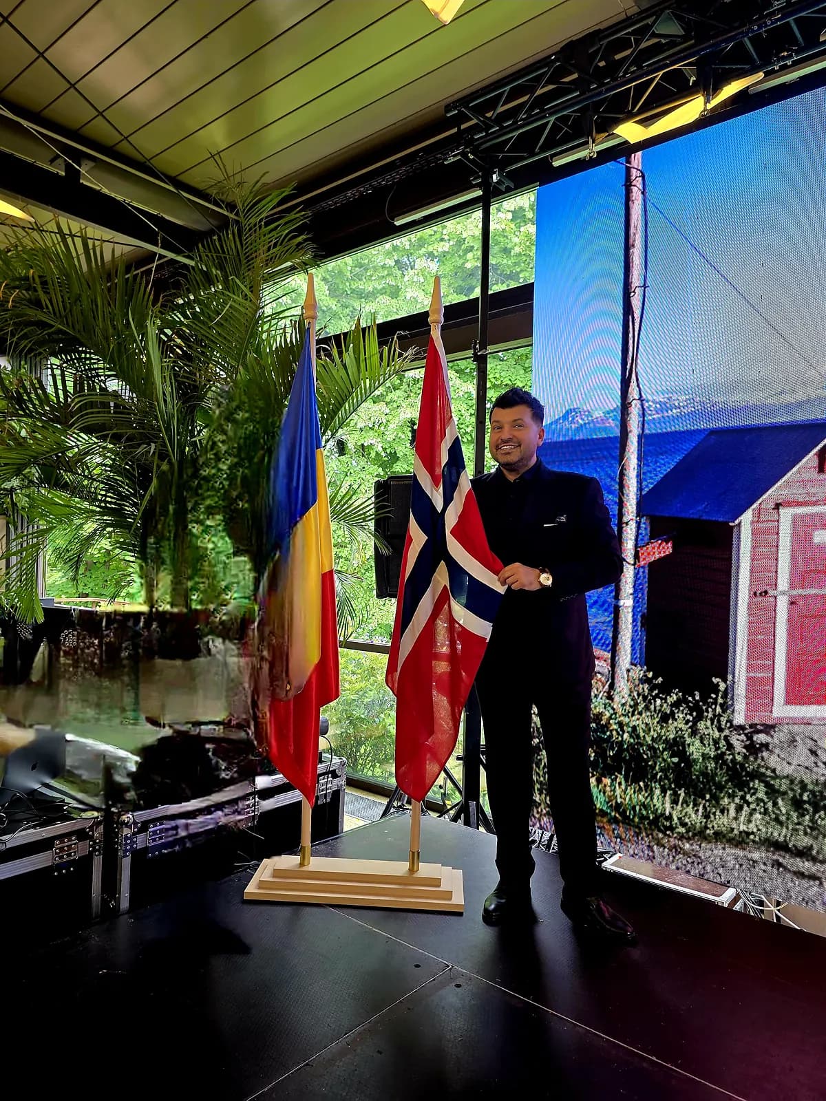 Gabriel Bîrjovanu pe scenă între drapelele României și Norvegiei — SCANDINAVIA Music School